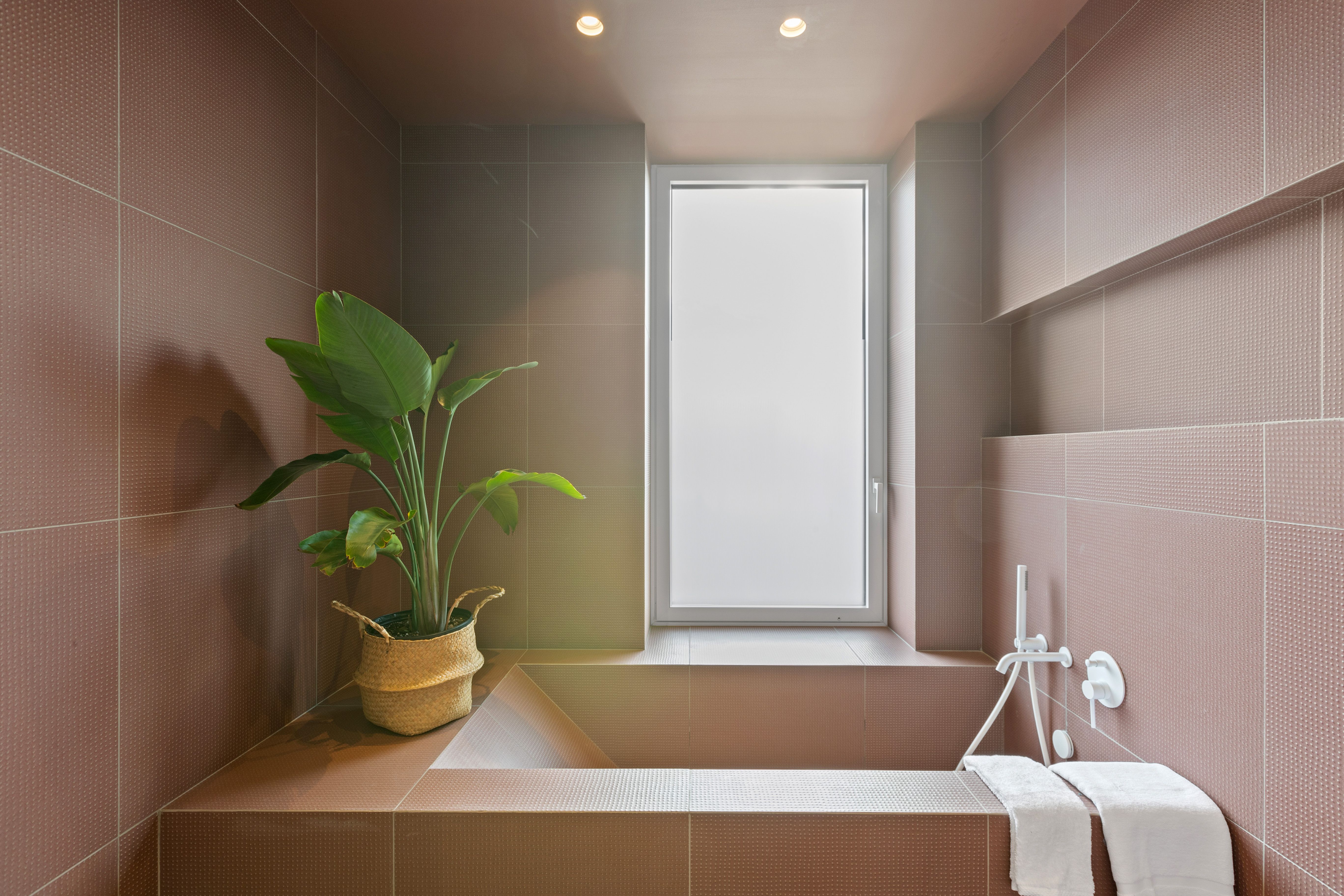 Bathtub in pink blush tiled bathroom